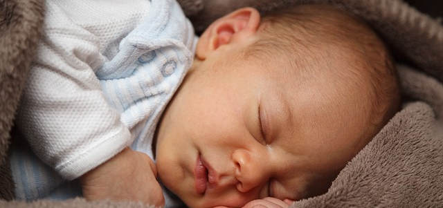 Ein Baby am schlafen. Sehr süß in eine Decke eingewickelt.